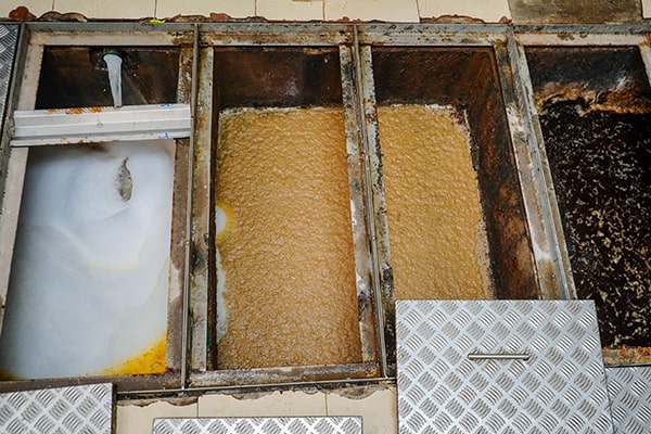 during grease trap maintenance, the trap is emptied, cleaned, and inspected for any issues or damage